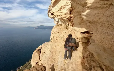 Grimpeur au **Cap Canaille**, face à la mer Méditerranée, prêt pour l'aventure sur les falaises calcaires.