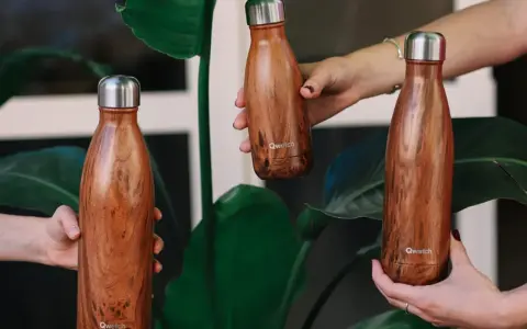 Trois gourdes inox au design bois, parfaites pour nettoyer et emporter vos boissons partout.