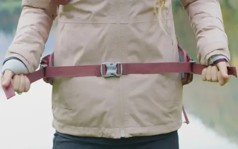 Ajustement de la ceinture d'un sac à dos de randonnée pour un confort optimal. La sangle est bien tendue.