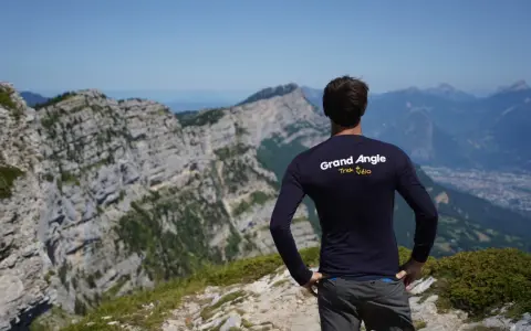 Un cycliste admire le panorama après un **tour du Vercors 7 jours**. Le paysage montagneux est spectaculaire.