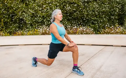 Femme âgée faisant un étirement des jambes, préparation pour un échauffement pieds randonnée.
