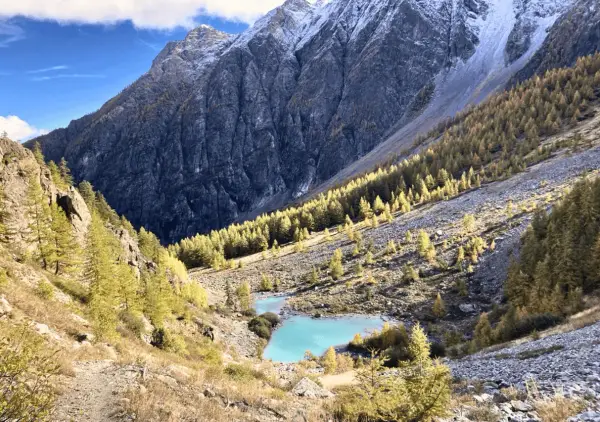 Magnifique lac turquoise au cœur d'une vallée alpine aux couleurs d'automne, parfait pour un tour des Écrins 10 jours.